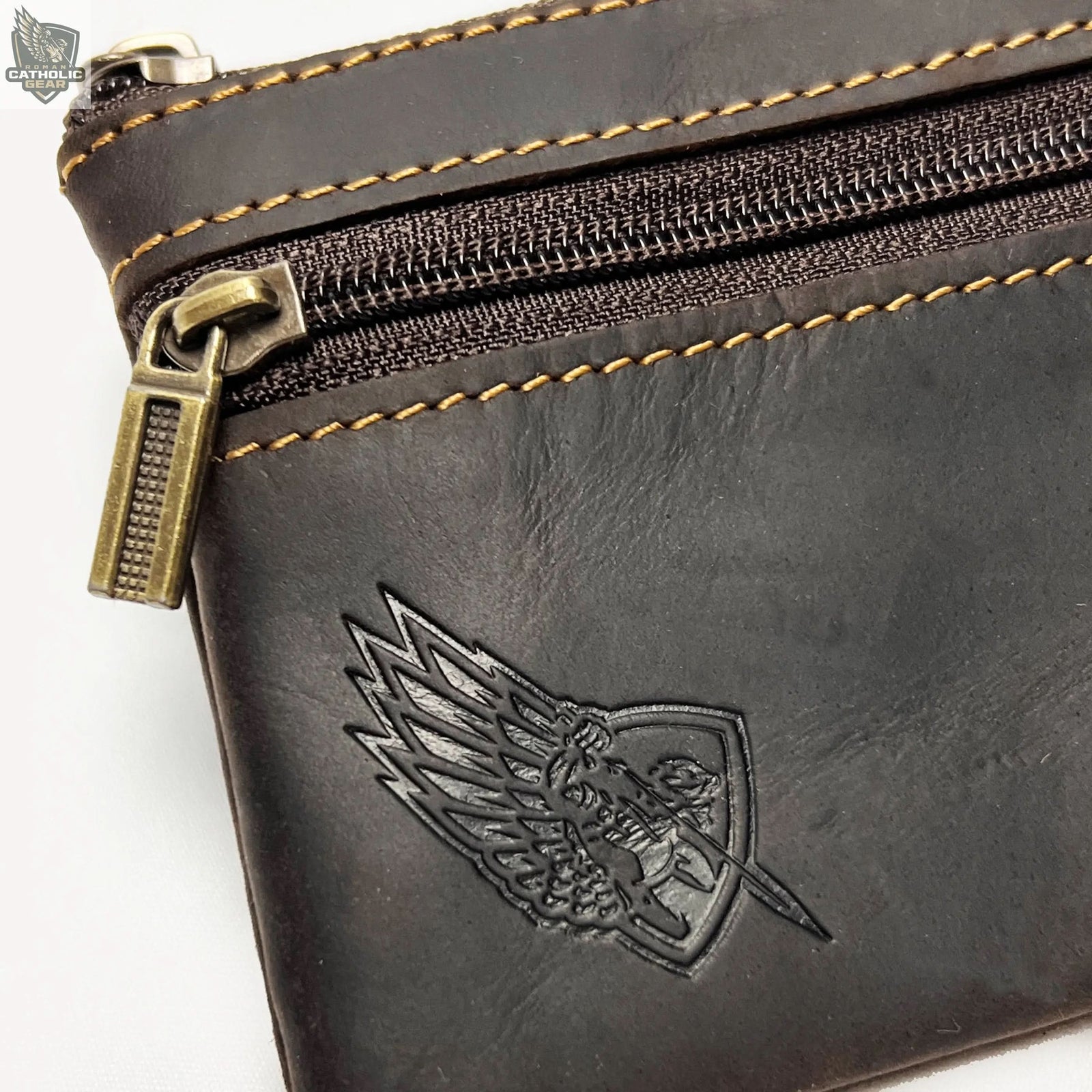 Four leather pouches in black, brown, and white on a wooden surface with a necklace.